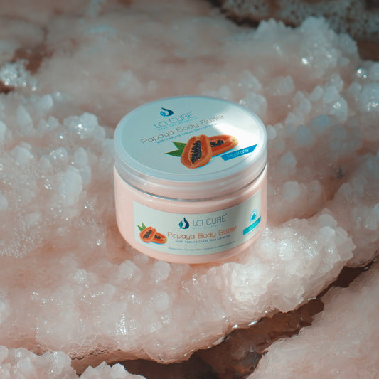 Jar of La Cure Papaya Body Butter on a textured pink surface